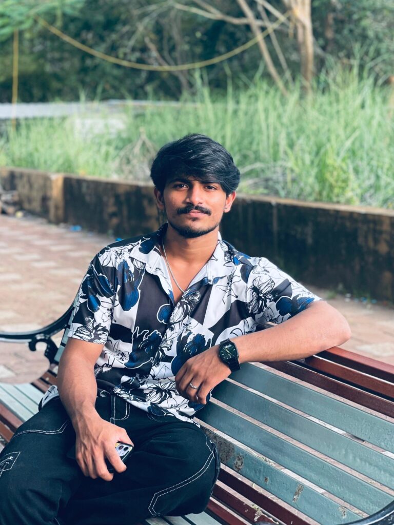 Freelance digital marketing consultant sitting outdoors on a bench, confidently posing with a relaxed expression.